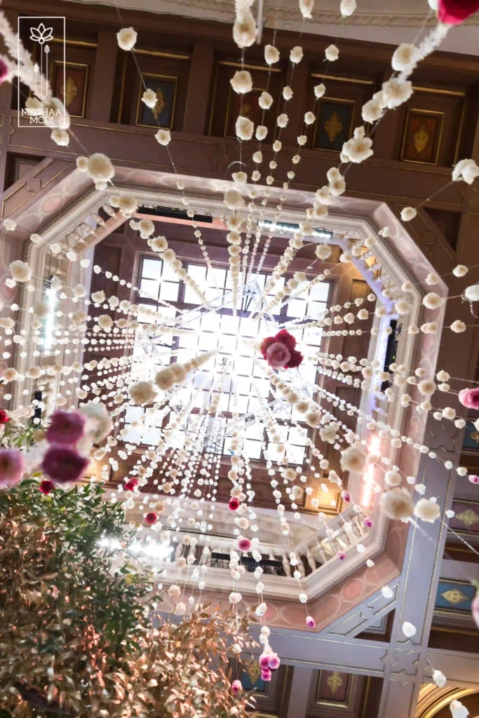 Looking up at a decorative floral installation hanging from an ornate octagonal ceiling